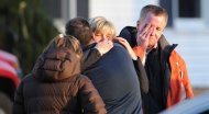 People grieve at the scene of a school shooting in Newtown, Connecticut. A young gunman slaughtered 20 small children and six teachers on Friday after walking into the school in an idyllic town with at least two sophisticated firearms