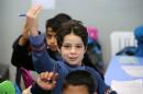 Syrian children attend a class at a school for refugees in the Lebanese village of Qaraoun on December 16, 2014