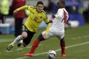 Colombia's James Rodriguez, left, is fouled by Peru's Luis Advincula during a Copa America Group C soccer match at the Bicentenario German Becker stadium in Temuco, Chile, Sunday, June 21, 2015. (AP Photo/Natacha Pisarenko)
