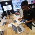 A salesperson unpacks an Apple iPad Mini to test it for a customer in the Apple specialty section of a Croma retail store in Mumbai