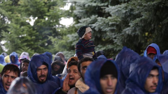 Migrants shout slogans at the border between Croatia and Slovenia in Trnovec, Croatia, Monday, Oct. 19, 2015. Hundreds of migrants have spent the night in rain and cold at Croatia&#39;s border after being refused entry into Slovenia. (AP Photo/Petr David Josek)