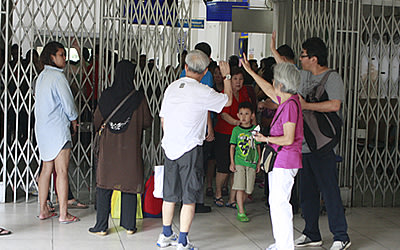 Passengers waving goodbye to their loved ones as they embark on a journey to Malaysia. (Yahoo! photo/ Marianne Tan)