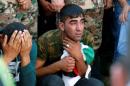 Brothers of Belal Al-Zuhbe, one of the solders killed in an attack on a border military post near a camp for Syrian refugees, cry during Al-Zuhbe's funeral at Nahleh village