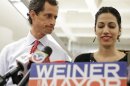 New York mayoral candidate Anthony Weiner glances at his wife, Huma Abedin, as she speaks during a news conference at the Gay Men's Health Crisis headquarters, Tuesday, July 23, 2013, in New York. The former congressman says he's not dropping out of the New York City mayoral race in light of newly revealed explicit online correspondence with a young woman. (AP Photo/Kathy Willens)
