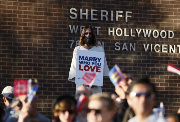 A man, dressed as Jesus, holds a sign in support of gay marriage in West Hollywood, after the United States Supreme Court ruled on California's Proposition 8 and the federal DOMA