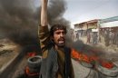 An Afghan protester shouts slogans near burning tyres during a demonstration in Kabul