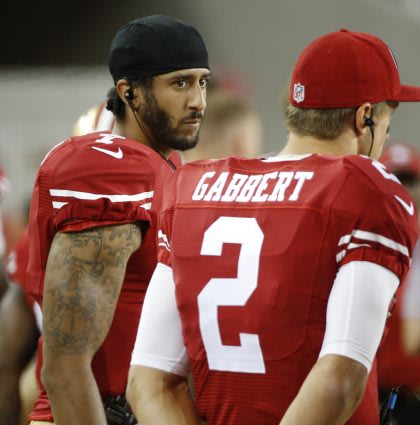 Colin Kaepernick, left, explains why he's refusing to stand during the national anthem (AP).