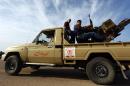 Members of a brigade loyal to the Fajr Libya, an alliance of Islamist-backed militias, sit on a pick up truck mounted with a machine gun on March 15, 2015 in Libya's coastal city of Sirte
