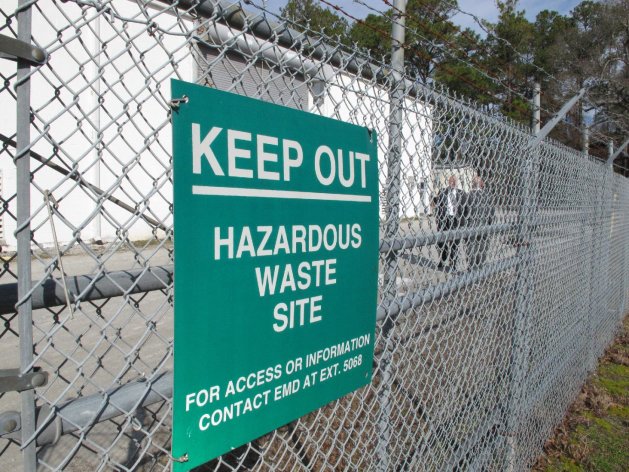 A sign cautions visitors outside a "pump and treat" facility on the Marine base at Camp Lejeune, N.C., on Wednesday, Feb. 27, 2013. The sprawling installation is the site of one of the worst drinking water contaminations in U.S. history. (AP Photo/Allen Breed)