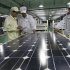 In this photo taken Wednesday March 21, 2012, Chinese workers examine solar panels at a manufacturer of photovoltaic products in Huaibei in central China's Anhui province. China's government on Friday, May 18, 2012,  rejected a U.S. antidumping ruling against its makers of solar power equipment and Chinese manufacturers warned proposed punitive tariffs might hurt efforts to promote clean energy.  (AP Photo) CHINA OUT