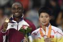 Gold medallist Qatar's Femi Seun Ogunode (L) and silver medallist China's Su Bingtian pose with their medals on the podium during the victory ceremony for the men's 100m athletics event during the 17th Asian Games in Incheon