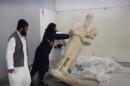 FILE - In this image made from video posted on a social media account affiliated with the Islamic State group on Thursday, Feb. 26, 2015, which has been verified and is consistent with other AP reporting, a militant topples an ancient artifact in the Ninevah Museum in Mosul, Iraq. The rampage by IS, targeting priceless cultural artifacts often spanning thousands of years, has sparked global outrage and accusations of war crimes. The militants are also believed to be selling ancient artifacts on the black market in order to finance their bloody campaign across the region. (AP Photo via militant social media account)