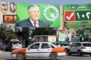 Vehicles drive past a giant poster featuring Iraqi President Jalal Talabani on September 18, 2013 in Iraq's northern city of Sulaimaniyah