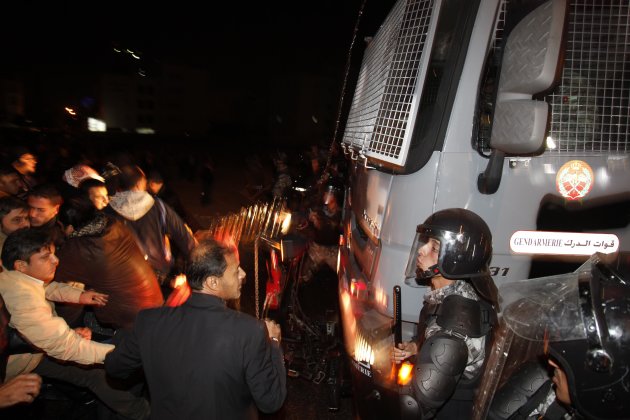 Protesters stand in front of a military truck near the Interior Ministry Circle during a demonstration following an announcement that Jordan would raise fuel prices, including a hike on cooking gas in Amman, Jordan, Wednesday, Nov. 14, 2012. (AP Photo/Mohammad Hannon)