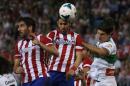 Atletico Madrid's Villa heads the ball next his teammate Garcia and Elche's Sapunaru during their Spanish first division soccer match at Vicente Calderon stadium in Madrid
