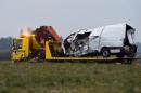 The wreckage of a minibus is towed from the accident site early on March 25, 2016 after it collided overnight with a truck in Montbeugny, central France