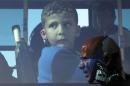 A refugee child is seen in a bus at Piraeus port near Athens