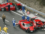 Police officers investigate damaged Ferrari cars at the site of a traffic accident on the Chugoku Expressway in Shimonoseki, southwestern Japan, Sunday, Dec. 4, 2011. Thirteen sports cars, including ...