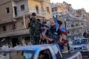 Armed rebel fighters from the Islamic Front drive their pickups on July 19, 2014 in the northern city of Aleppo