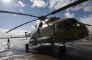 An Afghan soldier walks next to a refurbished Mi-17 helicopter at the military airport in Kabul