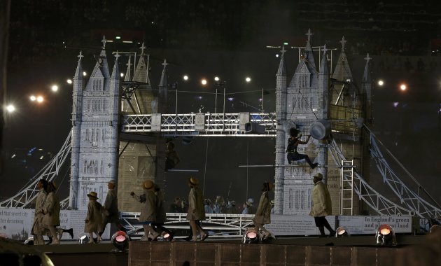Performers walk by a model of Tower Bridge during the closing ceremony of the London 2012 Olympic Games at the Olympic Stadium