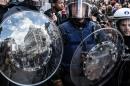 Riot police attend a memorial site during a protest by right wing demonstrators at the Place de la Bourse in Brussels, Sunday, March 27, 2016. In a sign of the tensions in the Belgian capital and the way security services are stretched across the country, Belgium's interior minister appealed to residents not to march Sunday in Brussels in solidarity with the victims. (AP Photo/Valentin Bianchi)