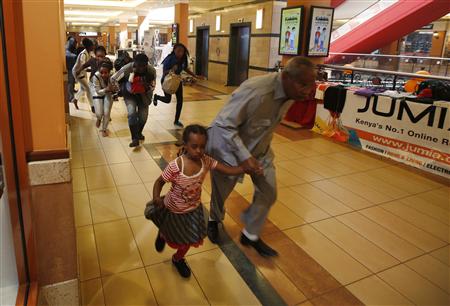 People with children run for safety as armed police hunt gunmen who went on a shooting spree at Westgate shopping centre in Nairobi