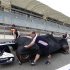 Williams Formula One mechanics push one of their team's car to the scrutineering area at the Bahrain International Circuit