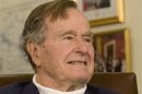 Former President Bush smiles as he listens to Republican presidential candidate Romney speak in Houston