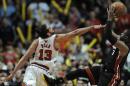 Joakim Noah, de los Bulls de Chicago, busca bloquear un disparo de Dwyane Wade, del Heat de Miami, en el partido del domingo 9 de marzo de 2014 (AP Foto/ Paul Beaty)