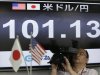 A TV cameraman films in front of monitor displaying Japanese yen's exchange rate against the U.S. dollar at a foreign exchange company in Tokyo