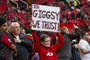 A young Manchester United supporter holds a placard in support of of interim manager Ryan Giggs before the team's English Premier League soccer match against Norwich City at Old Trafford Stadium, Manchester, England, Saturday April 26, 2014. (AP Photo/Jon Super)