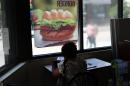 A woman eats in a fast food restaurant in a Brooklyn neighborhood on June 11, 2013 in New York City