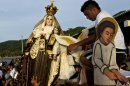 People carry a statue of the Virgin of Carmen during a procession at the dock of San Juan del Sur, Nicaragua, Tuesday, July 16, 2013. Nicaragua's fishing community celebrate the feast day of the Virgin Carmen who is worshipped by Catholics as the patron saint of fishermen and sailors. (AP Photo/Esteban Felix)