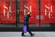 A man walks past a shop while carrying a shopping bag in New York, December 26, 2012. The 2012 holiday season may have been the worst for retailers since the financial crisis, with sales growth far below expectations, forcing many to offer massive post-Christmas discounts in hopes of shedding excess inventory. REUTERS/Eduardo Munoz
