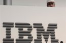 A worker is pictured behind a logo at the IBM stand on the CeBIT computer fair in Hanover February 26, 2011.