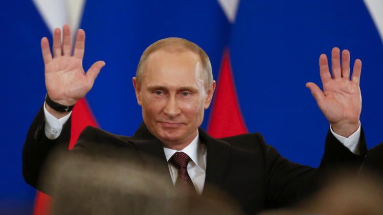 Russian President Vladimir Putin gestures after signing a treaty to incorporate Crimea into Russia in the Kremlin in Moscow, Tuesday, March 18, 2014. The crisis over Crimea is more than a dispute over whether the strategic Black Sea peninsula should be considered Russian or Ukrainian. At its root is a deeper issue: Russia’s simmering anger over its treatment by the West since the 1991 breakup of the Soviet Union. Russia’s biggest grievance has been the absorption into the NATO alliance not only of former Soviet allies, such as Poland and Romania, but also three republics that were part of the Soviet Union: Latvia, Lithuania and Estonia. The last straw was a European Union move to draw Ukraine closer to the West through a political association agreement. That set off a chain of events that led to the ouster of Ukraine’s pro-Russian president and, ultimately, to Russia’s annexation of Crimea. (AP Photo/Alexander Zemlianichenko)
