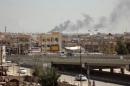 Smoke rises from buildings in Fallujah on March 21, 2014 after shelling