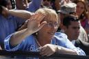 Presidential candidate and former President Michelle Bachelet waves to supporters after casting her vote during presidential elections in Santiago, Chile, Sunday, Dec. 15, 2013. Michelle Bachelet is widely expected to return to Chile's presidency by beating conservative rival Evelyn Matthei in Sunday's runoff vote. (AP Photo/Luis Hidalgo).