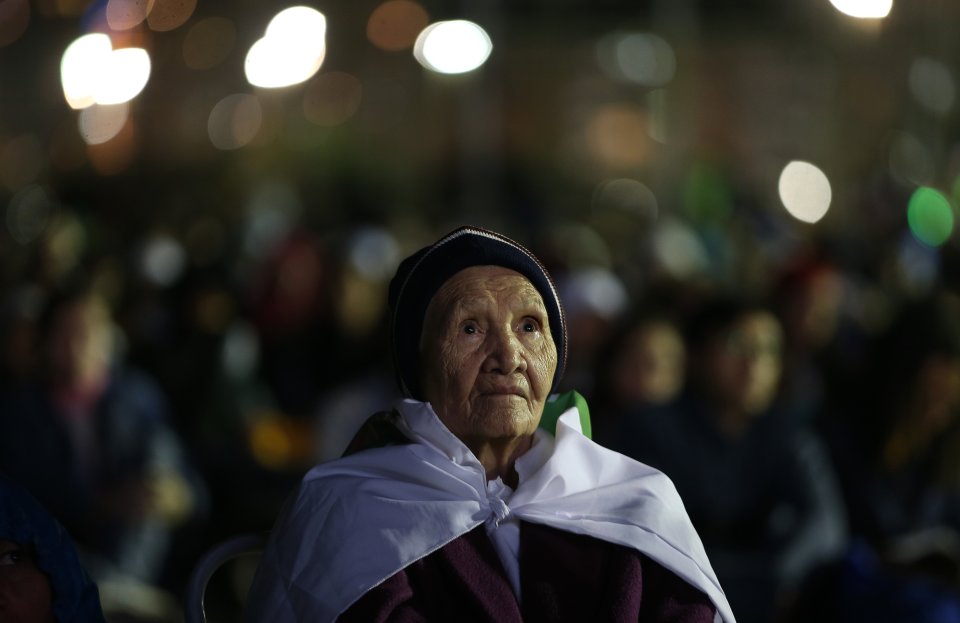 A woman watches a Stations of the Cross performance, on the Copacabana beachfront in Rio de Janeiro, Brazil, Friday, July 26, 2013. Pope Francis presided over one of the most solemn rites of the Catholic Church on Friday, a procession re-enacting Christ's crucifixion, that received a Broadway-like treatment; staging a wildly theatrical telling of the Stations of the Cross, complete with huge stage sets, complex lighting, a full orchestra and a cast of hundreds acting out a modern version of the biblical story. (AP Photo/Andre Penner)