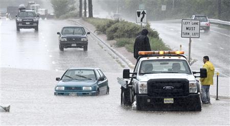 Tow crews work to assist stranded cars from South Boulder Road after heavy rains caused flooding in Boulder Colorado
