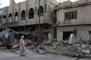 A man walks past the site of Wednesday's car bomb attack in Baghdad