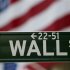 A Wall Street sign hangs on a signpost in front of the New York Stock Exchange
