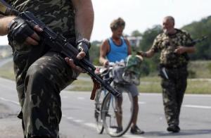 Armed pro-Russian separatists stand guard at a checkpoint …