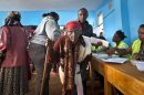 An elderly lady walks with a cane to cast her vote in the Mutumo primary school near Gatundu, north of Nairobi, in Kenya Monday, March 4, 2013. Multiple attacks against security forces in Kenya on Monday killed at least 12 people as Kenyans waited in long lines to cast ballots five years after more than 1,000 people died in election-related violence. (AP Photo/Ben Curtis)