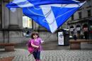 A child plays with a pro-independence 'Yes' flag on the streets of Aberdeen in Scotland, on September 15, 2014, ahead of the referendum on Scotland's independence
