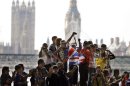 Fans cheer on runners in the men's marathon at the 2012 Summer Olympics, Sunday, Aug. 12, 2012, in London. (AP Photo/Mike Groll)