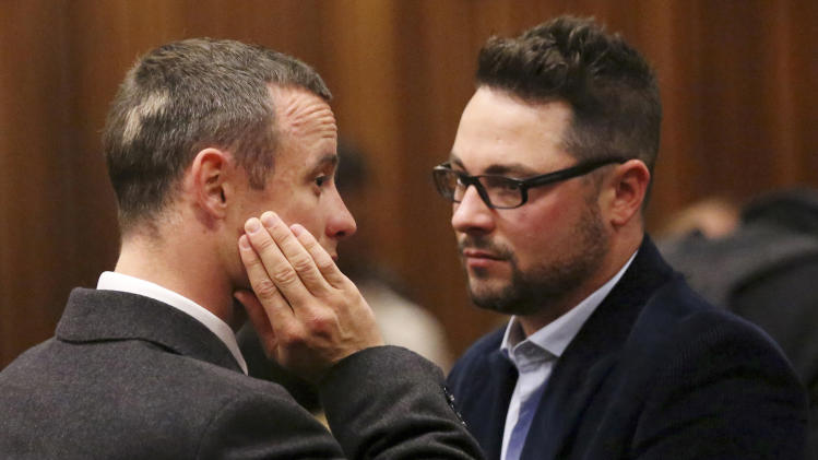  In this Tuesday May 20, 2014 file photo brother of murder accused, Oscar Pistorius, left, Carl Pistorius, right, speaks with his brother in court in Pretoria, South Africa. Aug. 1, 2014. Carl Pistorius has been discharged from an intensive care unit in the hospital after suffering internal injuries and going into respiratory failure following a car crash Aug. 1, 2014. (AP Photo/Siphiwe Sibeko, Pool, File)