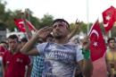 A protester salutes as he takes part in a rally in Taksim Square, Istanbul, Sunday, July 17, 2016. The Turkish government accelerated its crackdown on alleged plotters of the failed coup against President Recep Tayyip Erdogan, with the justice minister saying Sunday that 6,000 people had been detained in the investigation, including three of the country's top generals and hundreds of soldiers. (AP Photo/Petros Giannakouris)