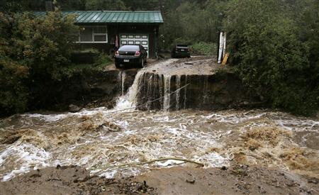 A home and car are stranded after a flash flood in Coal Creek destroyed the bridge near Golden, Colorado